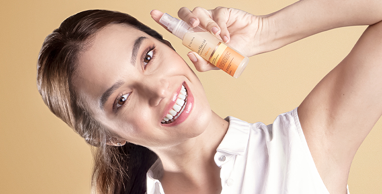 Mulher de cabelos escuros segurando, sorridente, o Firm Flaccid Nano Fluido Remineralizante na mão.